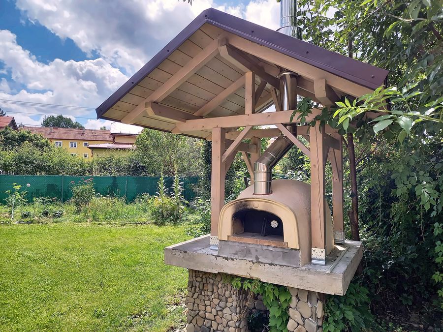 Venkovní pec na pizzu pod dřevěnou stříškou